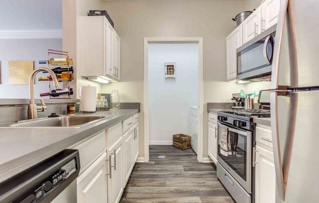a kitchen with stainless steel appliances and white cabinets