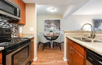 the kitchen and dining area of a home with a table and chairs