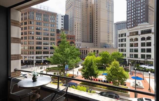 a view of the city from a window with trees and tall buildings