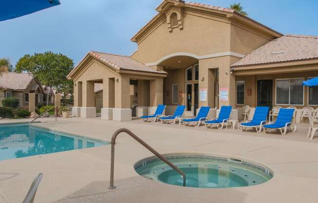 a swimming pool with blue chairs in front of a building