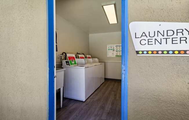 a laundry room with washing machines and a sign that reads laundry center