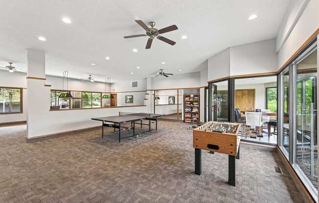 A room with a ceiling fan and a table with a wooden box on it.