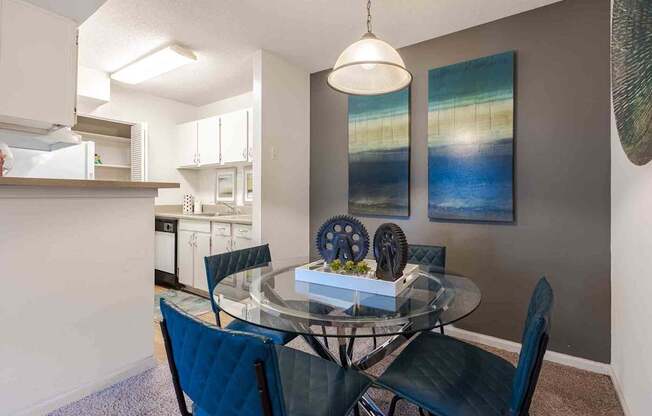 A dining room with a glass table and chairs.