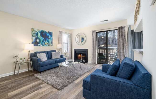 a living room with two blue couches and a fireplace