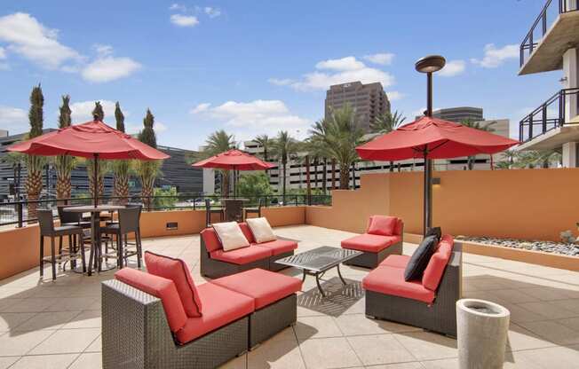 a terrace with couches tables and umbrellas