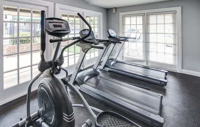 the gym is equipped with a treadmill and a large window