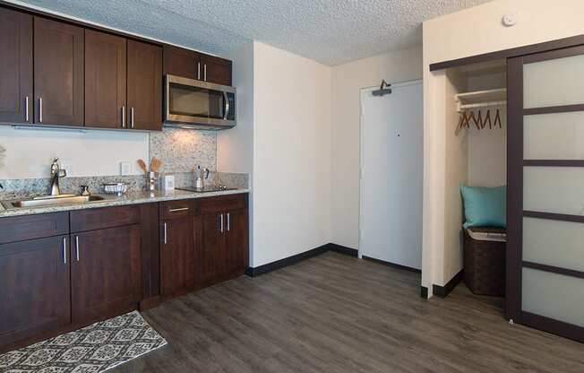 Waikiki Walina Apartments entry way with closet storage and kitchen area with appliances, cabinets, and counters