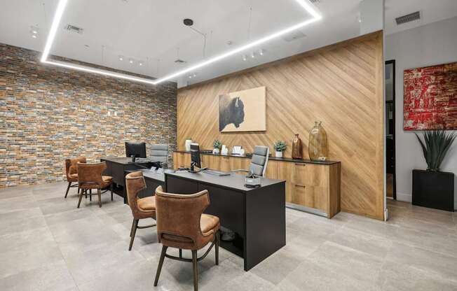 an office with a desk and chairs and a wall with a painting