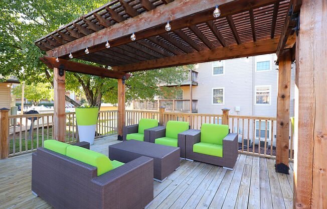 a patio with a pergola and furniture on a deck