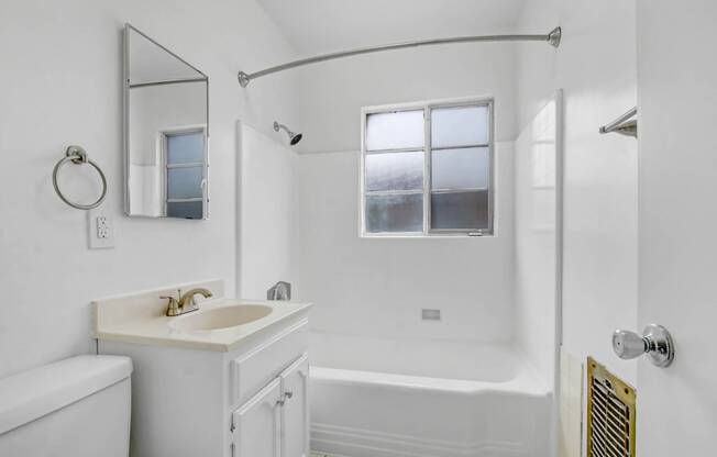 a white bathroom with a sink and a shower