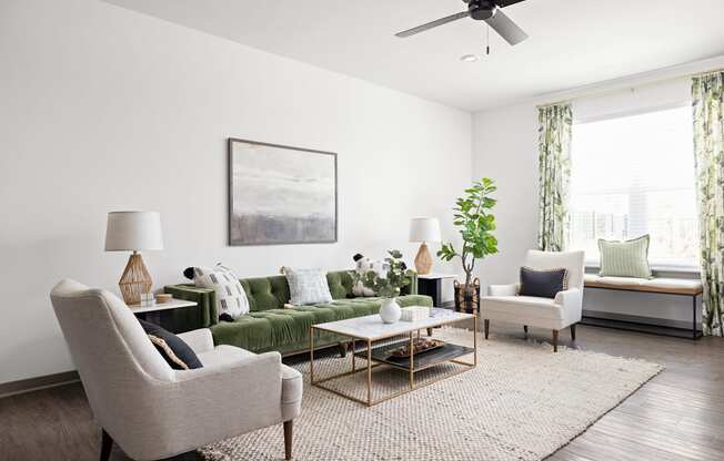 a living room with a green couch and chairs and a ceiling fan at Palm Grove in Ellenton, FL 34222