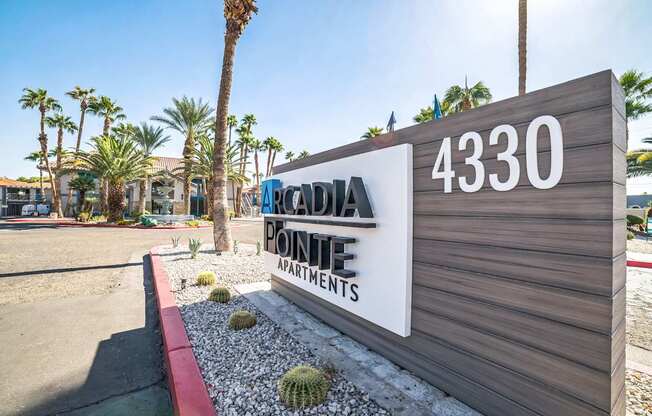 a sign that reads accadia pointe apartments in front of a building with palm