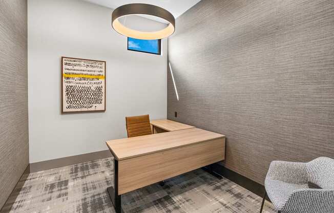 a desk in a room with a chair and a lamp