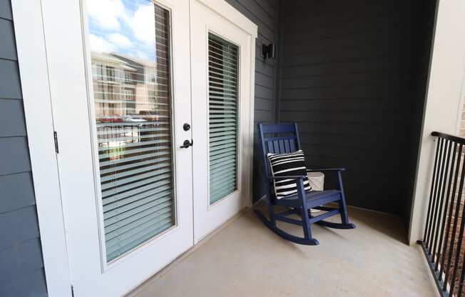 a rocking chair on a porch next to a door
