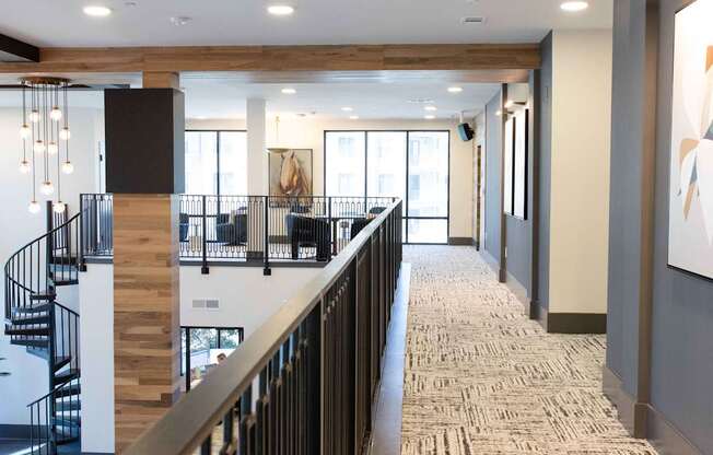 A hallway with a staircase and a carpeted floor.