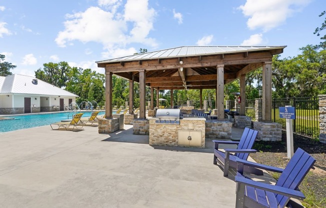 Grilling station at the pool area with seating at Capital Grand Apartments in Tallahassee, FL
