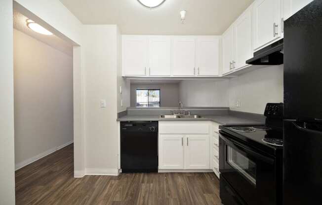 a 2-bedroom apartment kitchen with black appliances and white cabinets