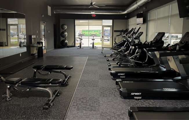 A gym with treadmills and elliptical machines.