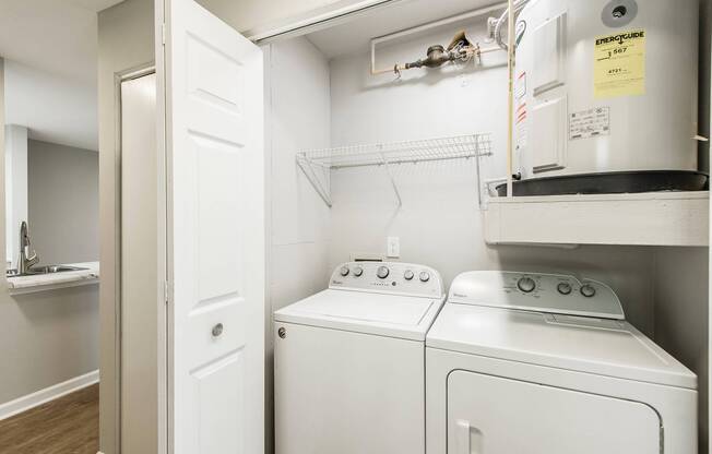 The laundry closet at our apartments in Antioch, featuring an in unit washer and dryer as well as a water boiler tank.