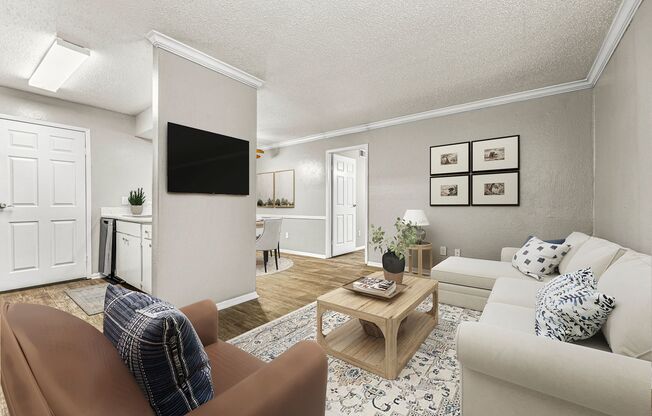 a living room with white furniture and a tv