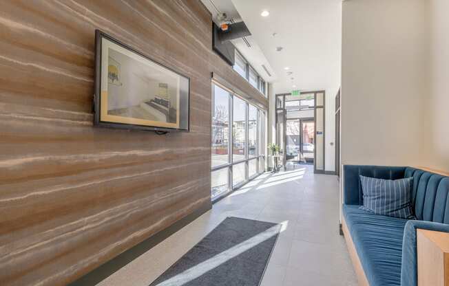 Hallway lobby with artistically textured walls and blue velvet loveseat at Marina Square, Bremerton