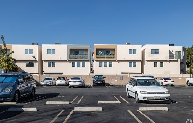 A parking lot with cars and a building in the background.