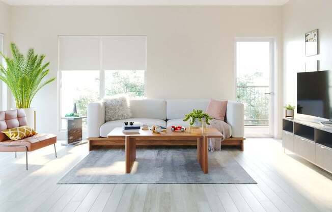 A modern living room with a white sofa, a wooden coffee table, and a TV on a cabinet.