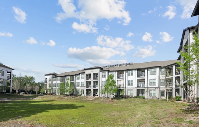 A large apartment complex with a grassy area in front.