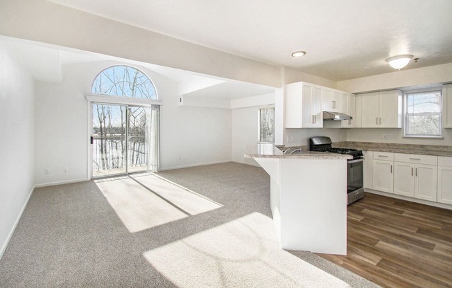 an open end style kitchen and living room with a door to a balcony at Canal 2 Apartments, Lansing, Michigan