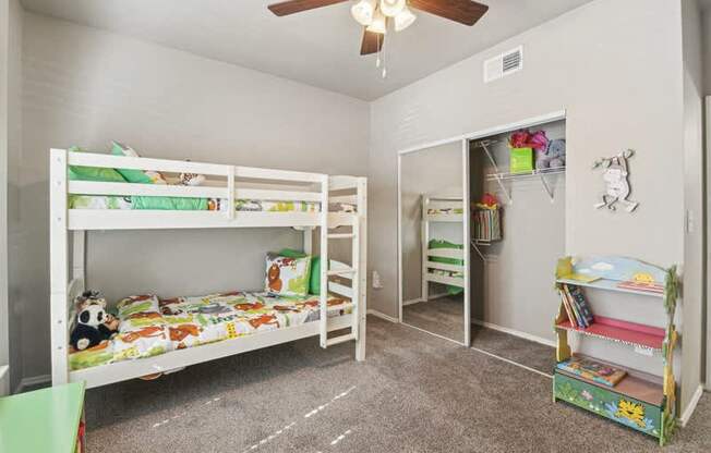 a bedroom with bunk beds and a ceiling fan