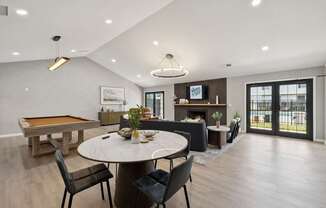 A modern dining room with a pool table and a fireplace.