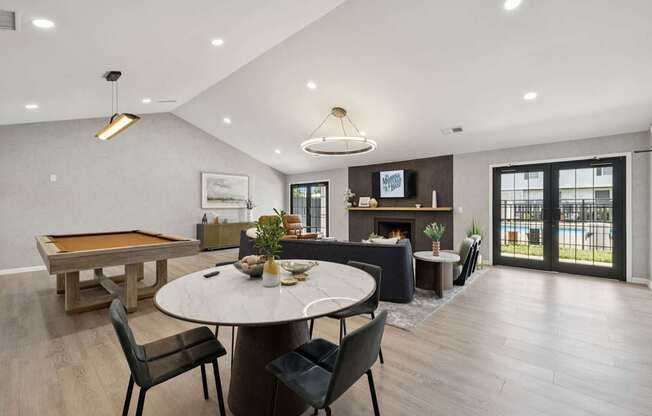 A modern dining room with a pool table and a fireplace.