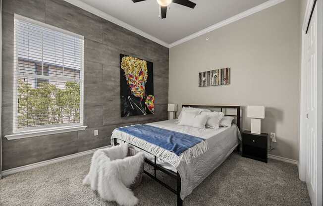 A bedroom with a bed, a ceiling fan, and a white cat.