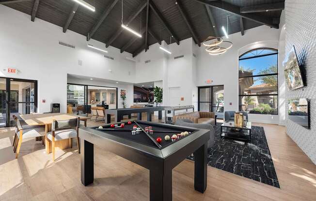 A room with a pool table and a foosball table.
