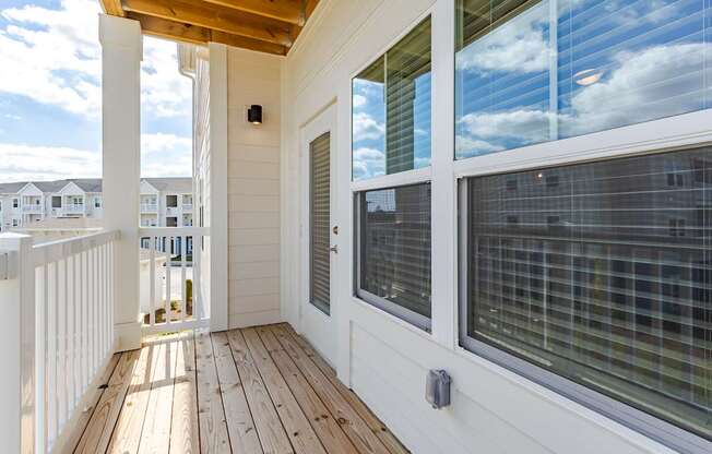 A balcony with a wooden floor and white railings.