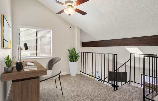 A room with a ceiling fan, a chair, a table, and a potted plant.