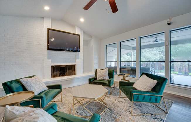 a living room with green chairs and a fireplace