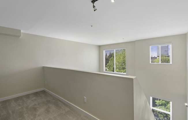 Loft-Style Bedroom with Wall to Wall Carpeting, and Multiple Window Views at Sir Gallahad Apartment Homes, Bellevue, 98004