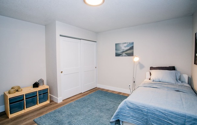 a bedroom with a bed and a blue rug