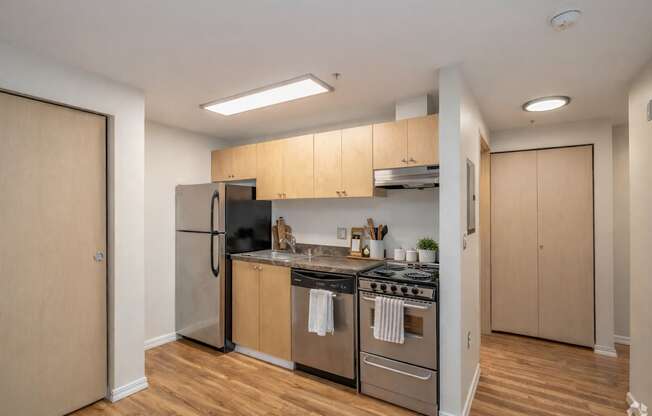 A kitchen with wooden floors and stainless steel appliances.