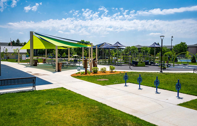 Outdoor playground with green and blue awnings and a walking path