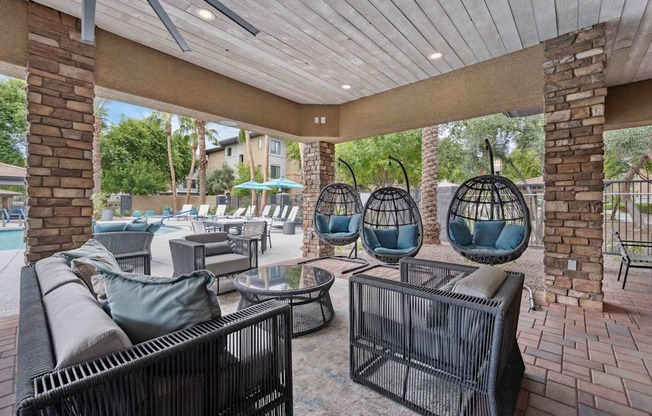 A patio with a black wicker chair and a table. at The Laurel Apartments, Arizona