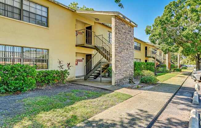 A yellow building with a balcony and a stone pillar.
