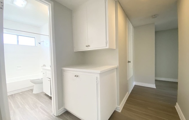 a renovated bathroom with white cabinets and a white toilet