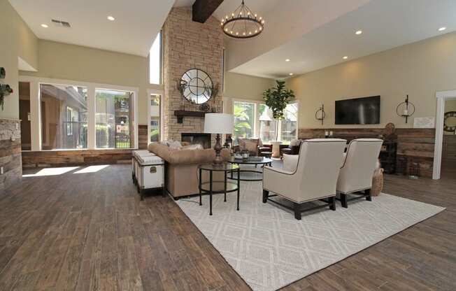 A living room with a fireplace and a large clock on the wall.