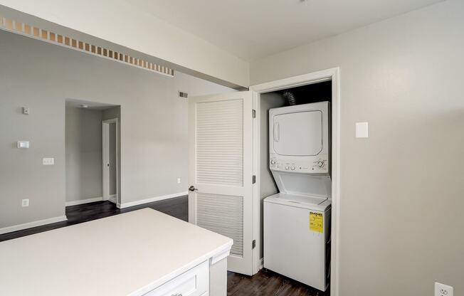 an empty kitchen with a washer and dryer and a laundry closet