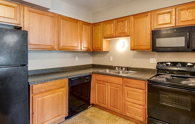 a kitchen with black appliances and wooden cabinets