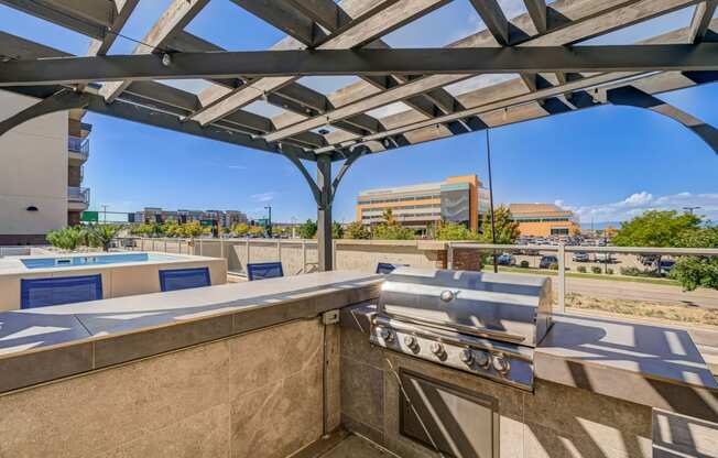 a gas grill on a patio with buildings in the background