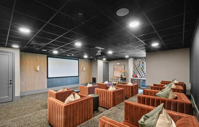 a large room with brown couches and a projector screen