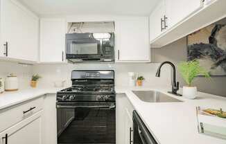 a white kitchen with a stove and a microwave